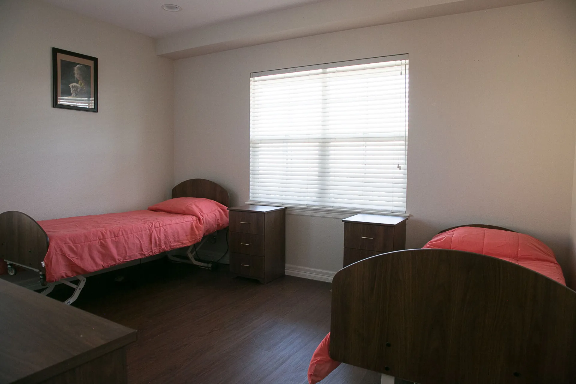 Another bedroom with two beds, dressers, and pictures on the walls.